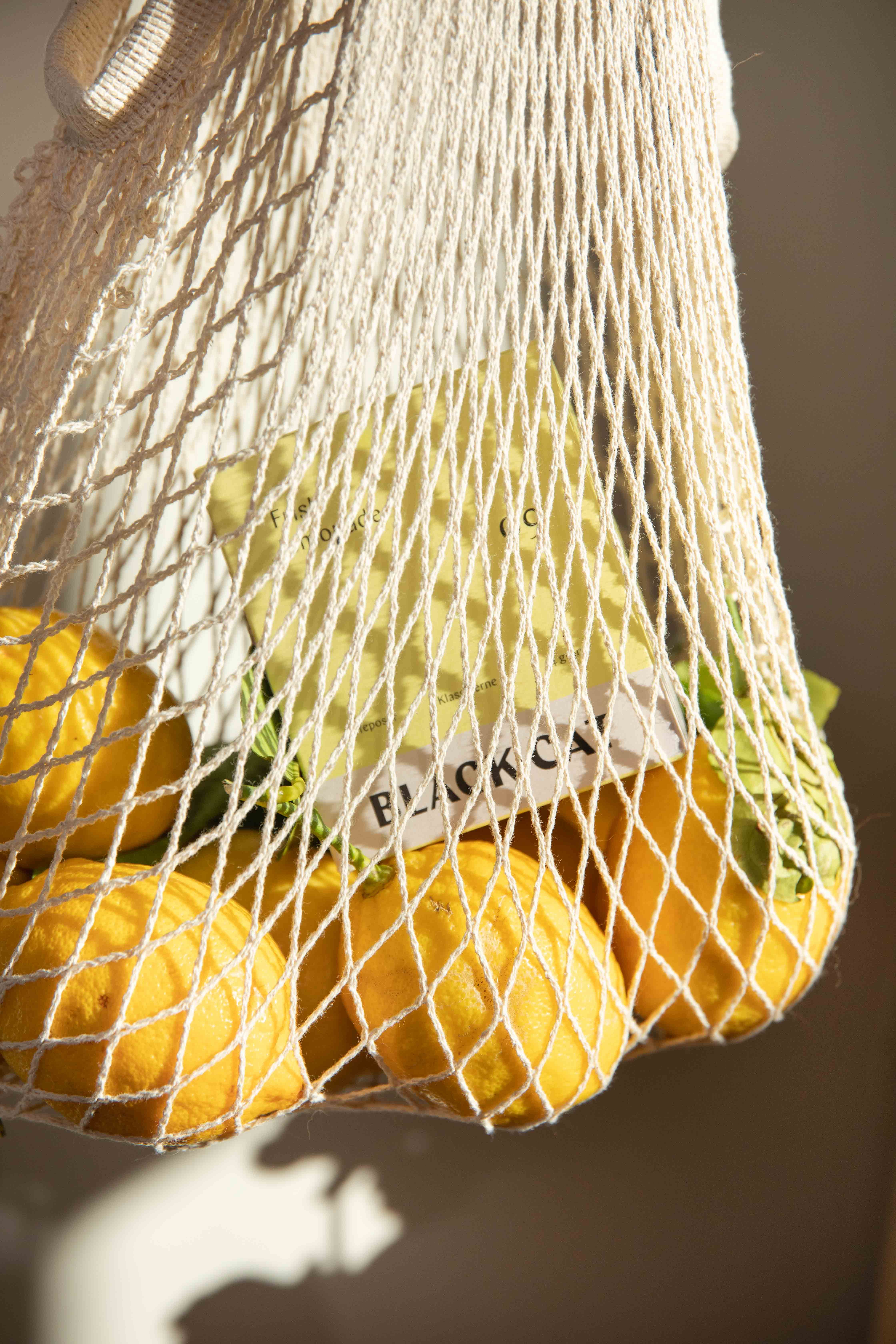 Et handlenett emd appelsiner og en teekse fra Black Cat