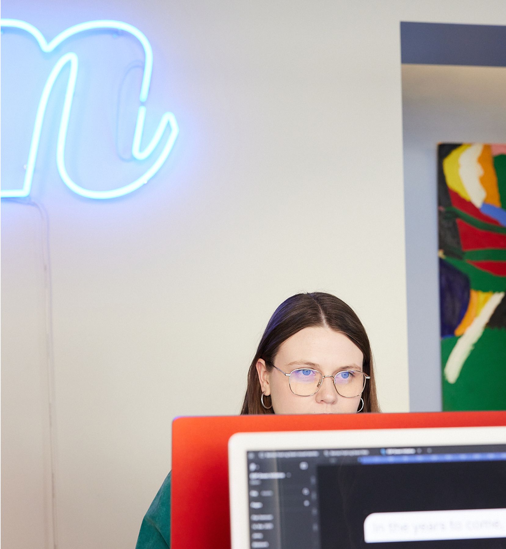 Julie sitter ved macen og jobber