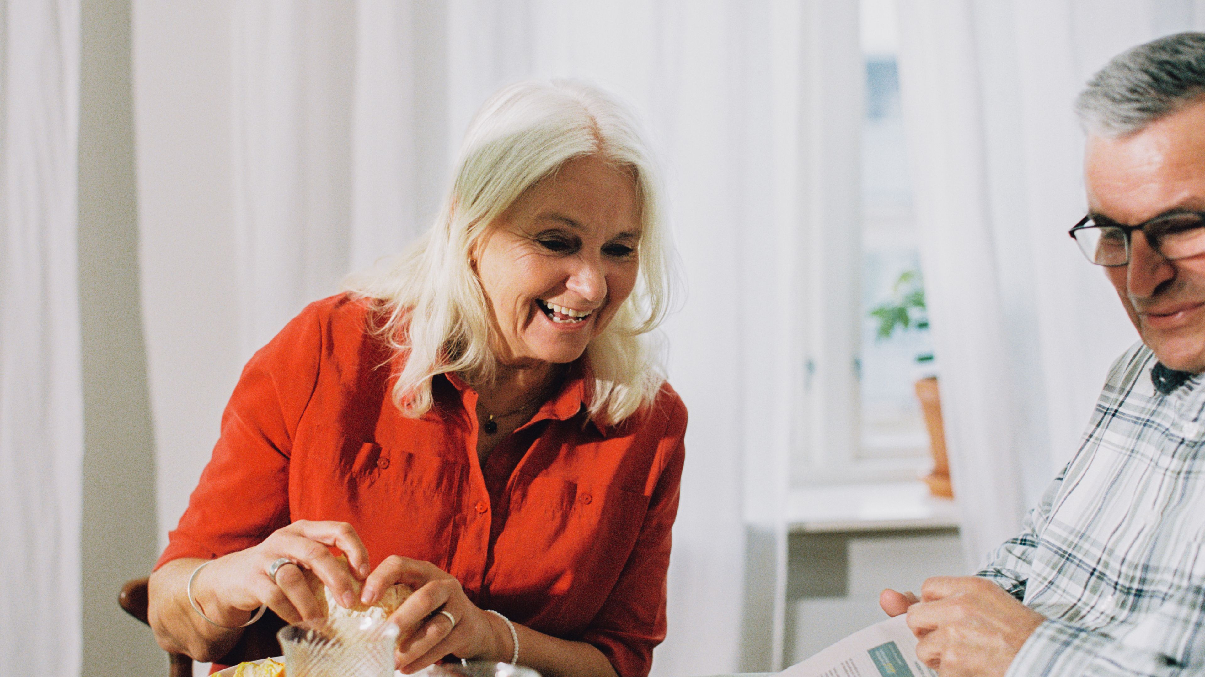Dame og mann som leser avisen sammen.