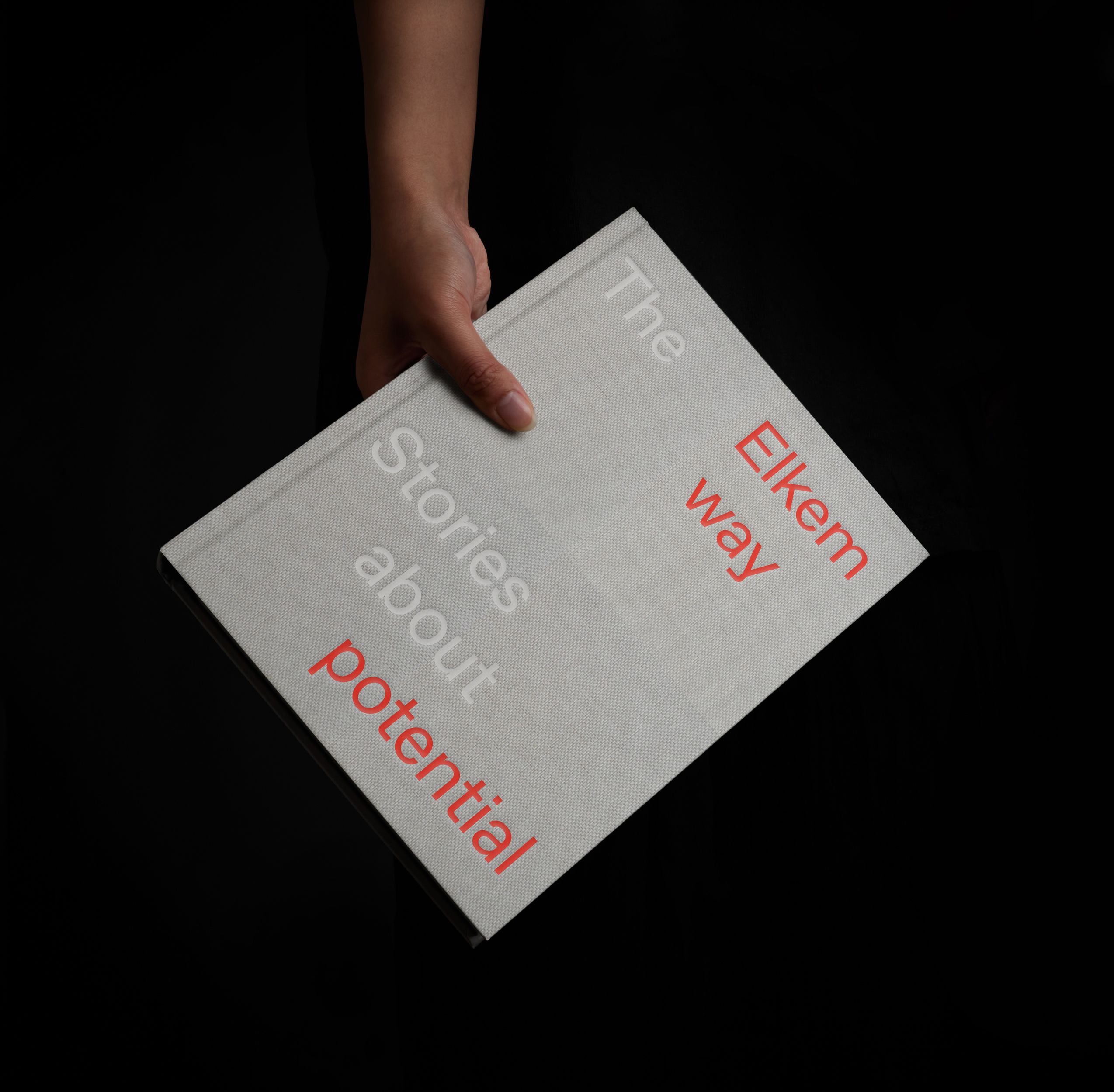 En som holder boken Elkem Way