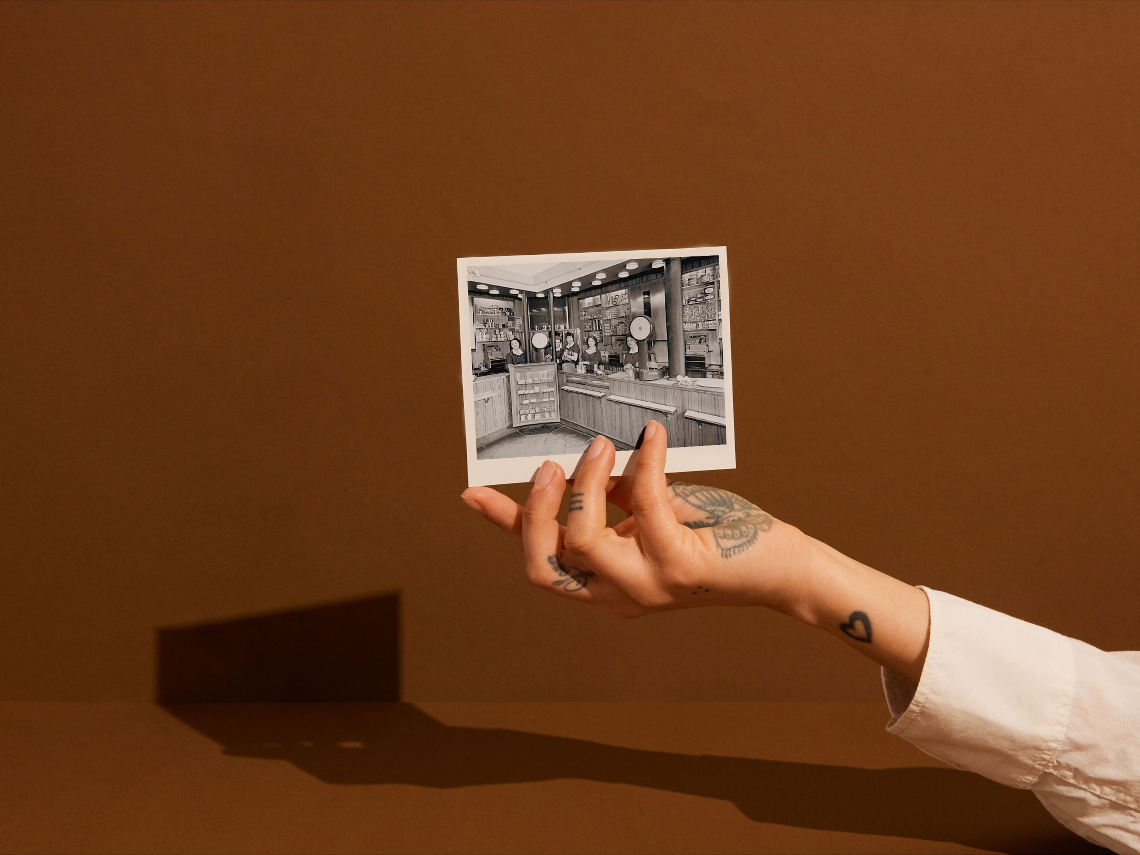 En kvinne holder et gammelt bilde av Black Cat butikk